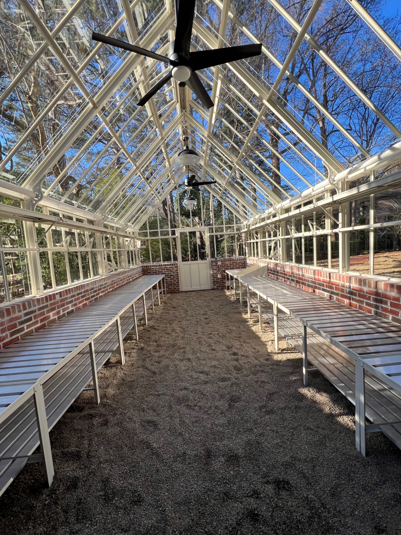 Interior of a custom greenhouse with brick base and finished walkways