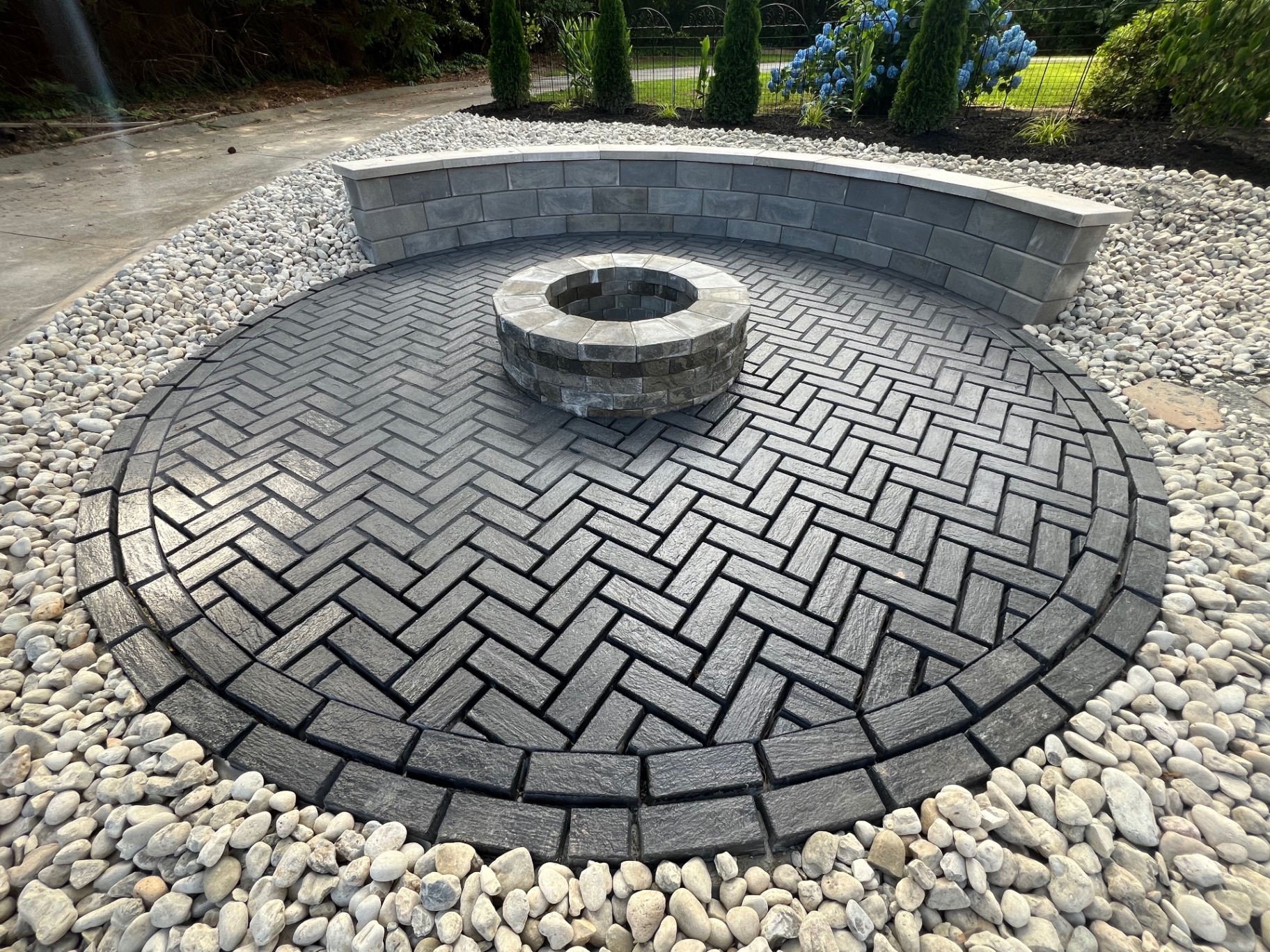 Herringbone paver fire pit patio with curved seat wall