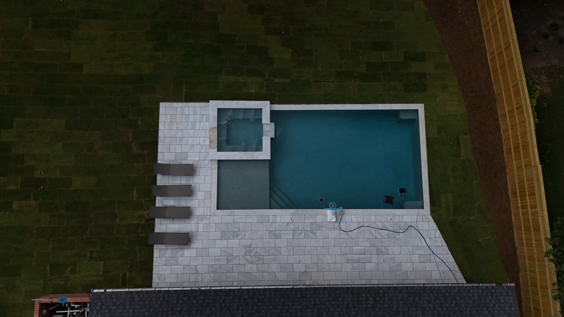 Aerial view of pool and marble-look paver deck